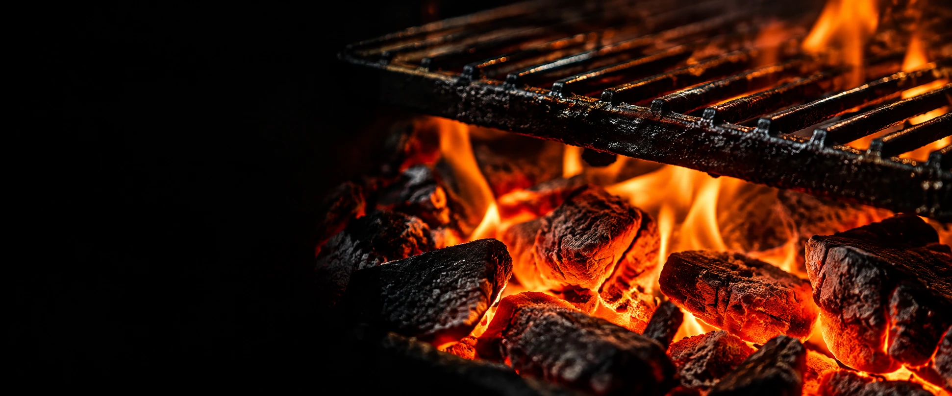 Glowing embers beneath a restaurant grill